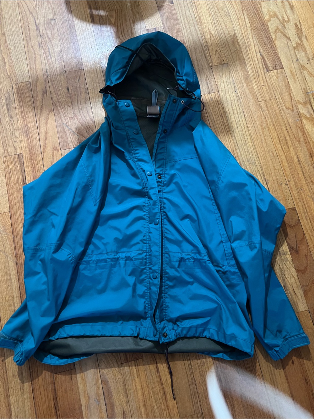 EMS women’s large Lightweight hooded rain jacket in a vibrant teal color.